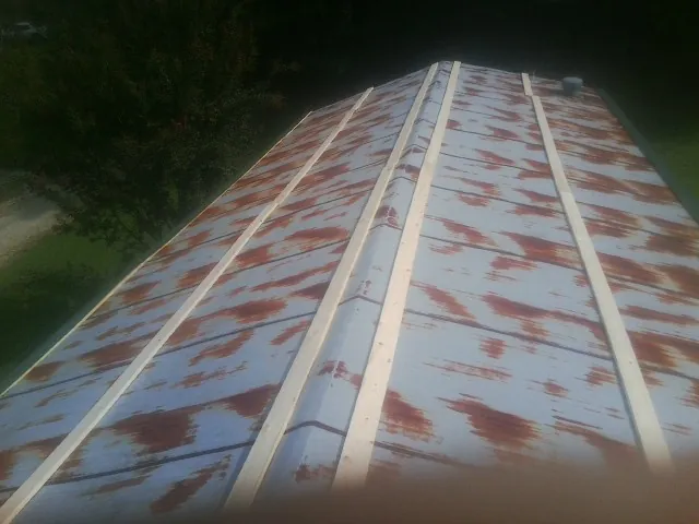 Rusted metal roof panels with new wood purlins before replacement — Storm Damage Roof Repair in Bolivar by Roofing Brothers